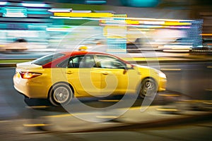 Speeding Taxi Car Fast Driving In City Street. Motion Blur Background