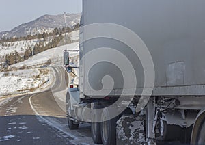 Speeding truck wheels on icy road during winter storm