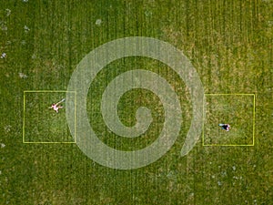 Speedminton being played by two players on a grassy pitch outdoors