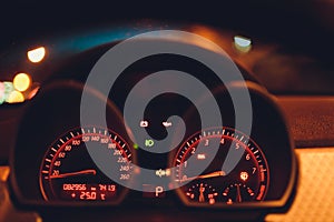 Speedometer scoring high speed in a fast motion. Sporty Car Dashboard Instruments illuminated at night. Rev counter