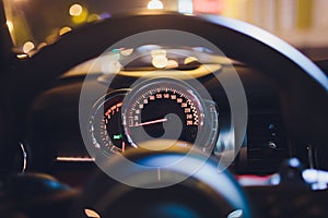 Speedometer scoring high speed in a fast motion. Sporty Car Dashboard Instruments illuminated at night. Rev counter