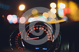 Speedometer scoring high speed in a fast motion. Sporty Car Dashboard Instruments illuminated at night. Rev counter