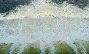 Speedy water from dam shutter texture background with bubbles.