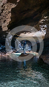 Speleologist in a cave with calcite incrustations
