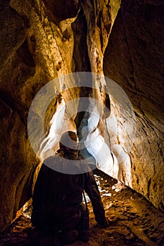 Speleologist exploring old tunnel in a cave