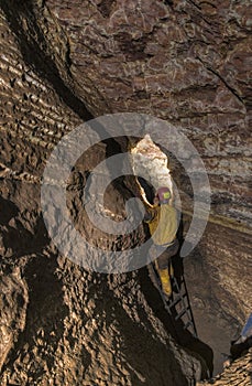 Speleologist in front of difficult place in cave