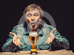 The spellbound man in denim shirt with glass of