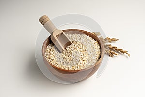 Spelt bran and grains in clay pot isolated on white background