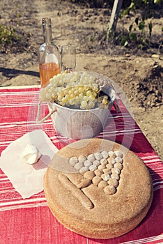 Spelt bread and grapes with bottle of white wine on a table