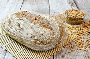 Spelt bread with spelt grain on wooden table