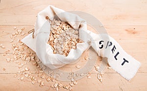 Spelt flakes in a cream fabric bag with a stencilled label