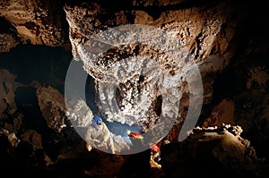 Spelunker admiring beautiful stalactites in a cave photo