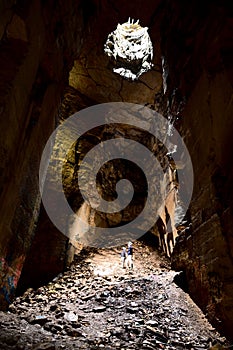 Spelunkers standing in chamber in abandoned mine in Wiltshire, UK