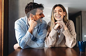 Spending nice time at home. Beautiful young loving couple bonding to each other and smiling