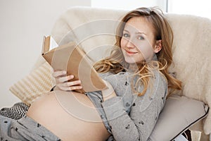 Spending precious time of soon ending pregnancy. Portrait of young charming cheerful pregnant mother with blond hair