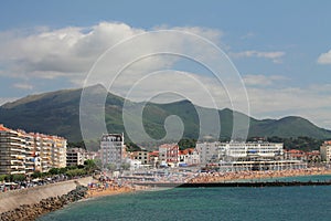 Spending summer holidays on sandy beach of saint jean de luz with mountain la rhune rising up in blue sky, basque country, france