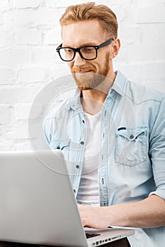 Spending time with his laptop.