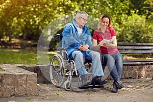 Spending time together reading book outdoor daughter and disable