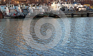 Spent river tugboats stand near the pier. The crisis of river transport.