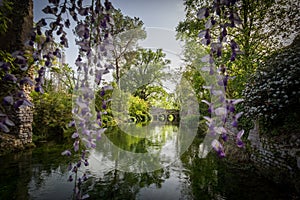 Spettacula bridge in the green wather of the river in the Garden