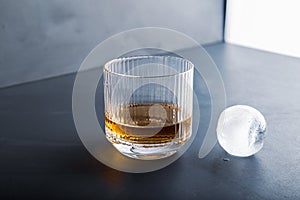 Sphere shaped ice cube and close up whiskey