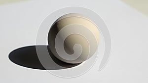 On the sphere from the upper left casting a distinct soft shadow to the