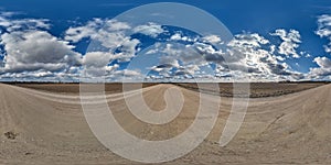 spherical 360 hdri panorama on gravel road with clouds and sun on blue sky in equirectangular seamless projection, use as sky