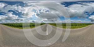 spherical 360 hdri panorama on old asphalt road among corn fields with clouds and sun on blue sky in equirectangular seamless