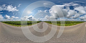 spherical 360 hdri panorama on old asphalt road among corn fields with clouds and sun on blue sky in equirectangular seamless