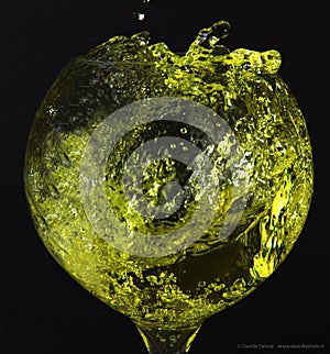 A spherical glass-shaped glass with a yellow liquid splash