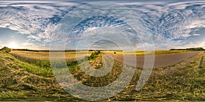 Spherical hdri panorama 360 degrees angle view near asphalt road among fields in summer evening sunset with cirrocumulus clouds in