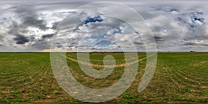spherical 360 hdri panorama among green grass farming field with clouds on overcast sky in equirectangular seamless projection,