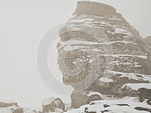 The Sphinx Sfinxul, a natural rock formation in the Bucegi Natural Park, in the Bucegi Mountains of Romania, during a blizzard
