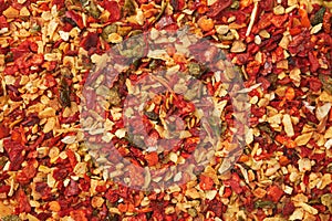 Spice mix for cooking dishes. Flakes of red hot pepper, paprika, garlic, onion. Dried seasoning closeup.