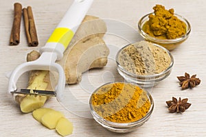 Spice set: ginger root and vegetable cutter, ginger and turmeric powder, turmeric paste on a light background