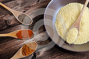 Spice on spoon with bowl of couscous