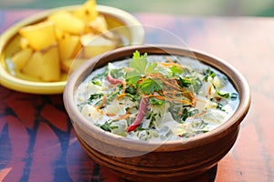 spiced potato raita with whole green chilis garnish