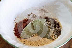 Spices and bay leaf closeup mixed together photo