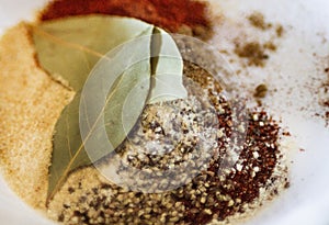 Spices and bay leaf closeup mixed together photo