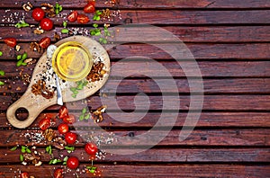 Spices, cherry tomatoes, basil and vegetable oil on dark wooden table, top view