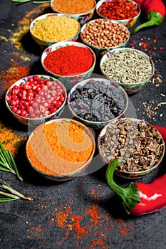 Spices. Colorful spices. Curry, Saffron, turmeric, cinnamon and otheron a dark concrete background. Pepper. Large collection of di