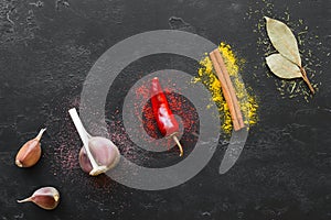 Spices and condiments with herbs on a black background