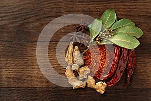 Spices on dark wooden background, view from above