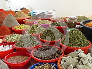 Spices and different kind of herbal teas  exposed in colored recipients  in a market of Uzbekistan.