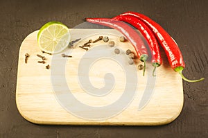 Spices and empty cutting board/spices and empty cutting board on a dark background. Top view. Copy space