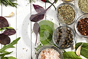 Spices and fresh herbs on a white wooden background. Top view