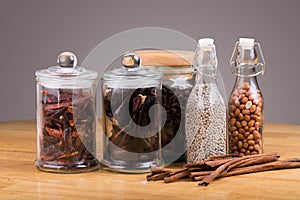 spices in glass bottles on wooden background.