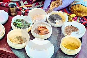 Spices in half-empty bowls for sale on the market. Trade of spices at the Bazaar. A Muslim spice merchant`s shop