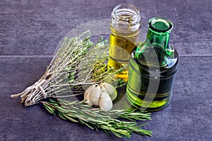 Spices, herbs and garlic, olive oil next to a bottle