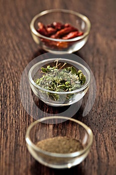 Spices and herbs in glass bowls.